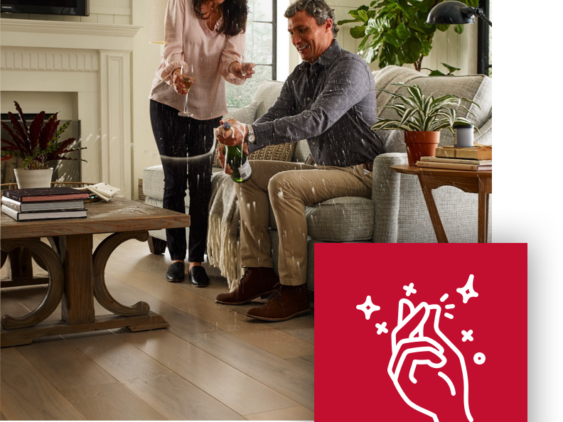 couple popping prosecco in living room